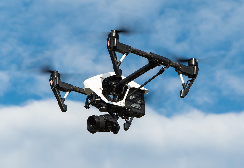 drone flying overhead holding a camera