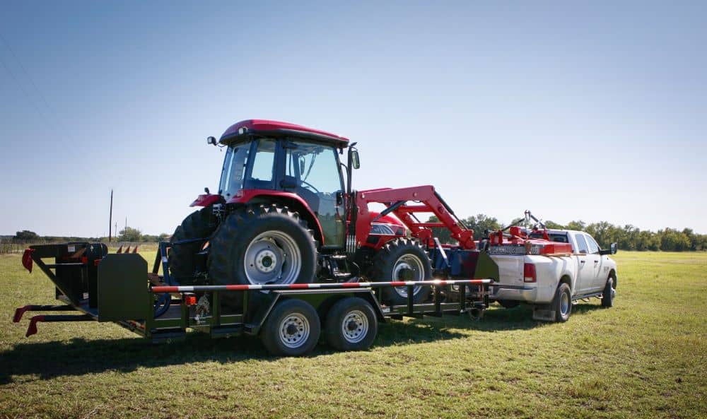 A red tractor being towed.