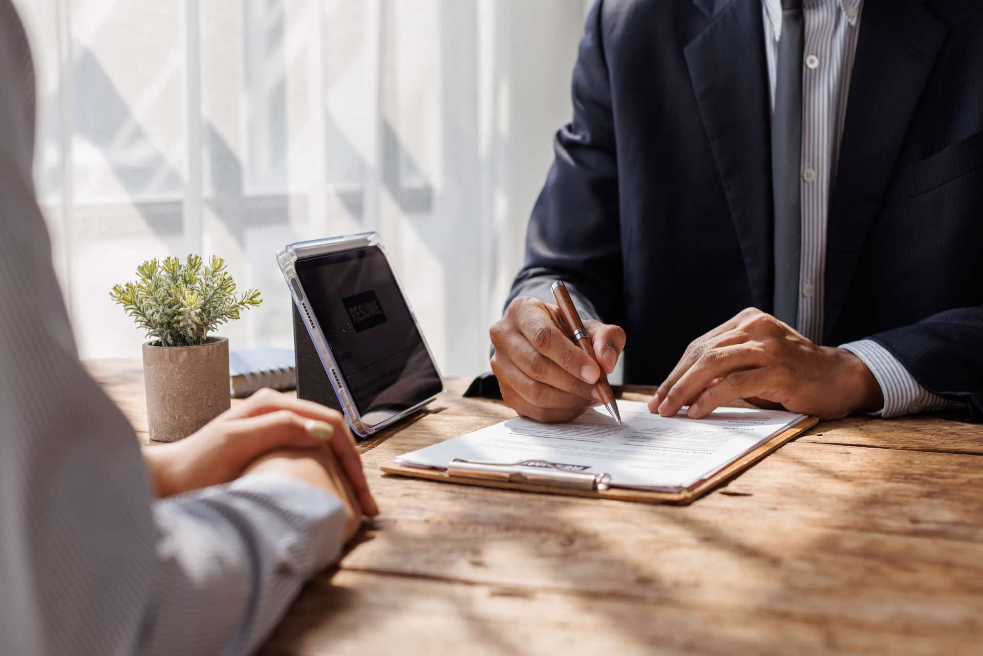 Labour hire insurance broker at desk with client signing contract