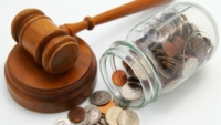 Gavel and coins in a fallen jar representing association indemnity cover